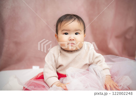 ピンクバックで座っている赤ちゃん 122002248