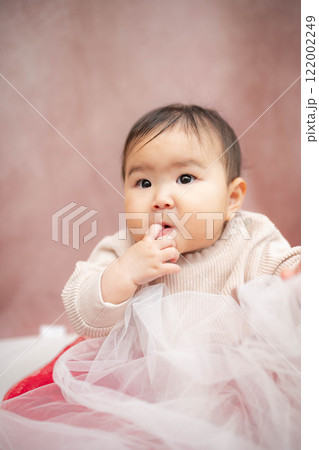 ピンクバックで座っている赤ちゃん 122002249
