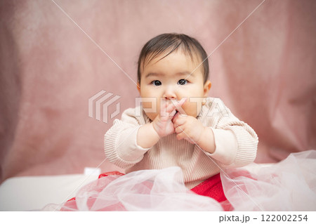 ピンクバックで座っている赤ちゃん ピンクバックで座っている赤ちゃん 122002254