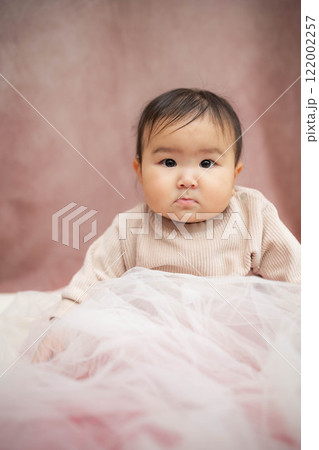 ピンクバックで座っている赤ちゃん 122002257