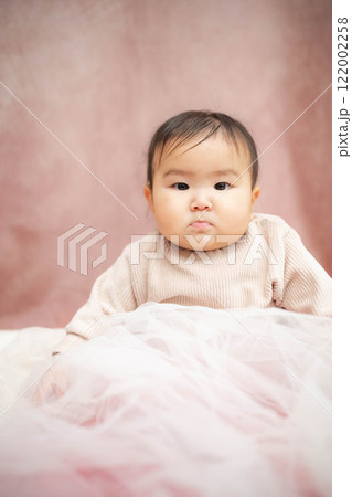 ピンクバックで座っている赤ちゃん 122002258
