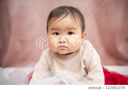 ピンクバックで座っている赤ちゃん ピンクバックで座っている赤ちゃん 122002259