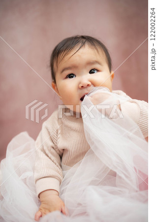ピンクバックで座っている赤ちゃん ピンクバックで座っている赤ちゃん 122002264
