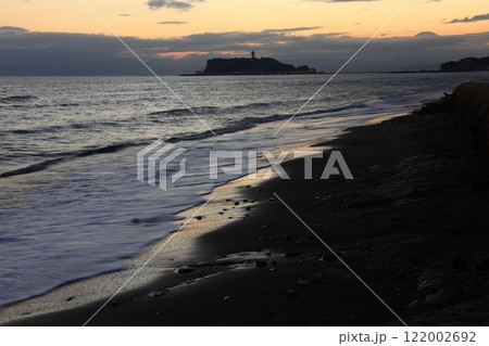 鎌倉・七里ヶ浜海岸から見る江ノ島とオレンジ色になる夕陽とのある風景　夕景 122002692