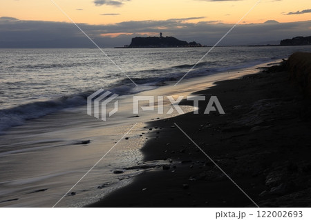 鎌倉・七里ヶ浜海岸から見る江ノ島とオレンジ色になる夕陽とのある風景　夕景 122002693