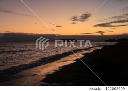 鎌倉・七里ヶ浜海岸から見る江ノ島とオレンジ色になる夕陽とのある風景 夕景 鎌倉・七里ヶ浜海岸から見る江ノ島とオレンジ色になる夕陽とのある風景 夕景 122002699
