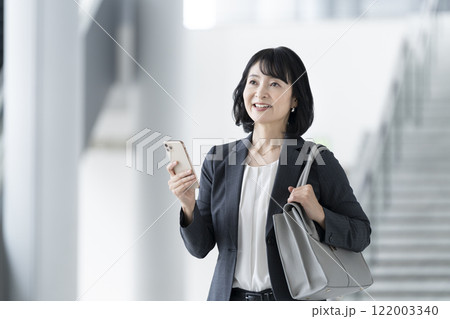 スマートフォンを持ったアラフィフのビジネスウーマン スマートフォンを持ったアラフィフのビジネスウーマン 122003340