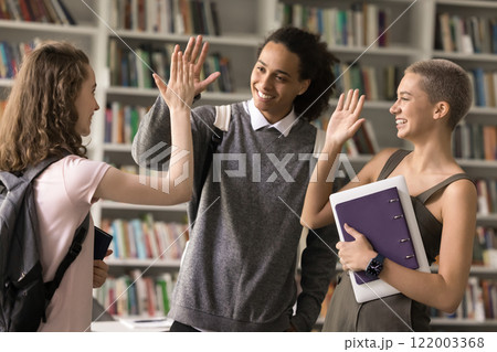 Excited diverse teenage ethnic students join palms in high five Excited diverse teenage ethnic students join palms in high five 122003368