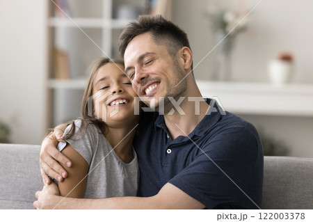 Adorable little daughter and young loving dad cuddling with tenderness Adorable little daughter and young loving dad cuddling with tenderness 122003378