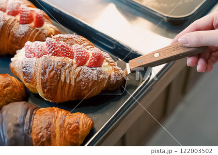 クロワッサンとを取り分ける手 122003502
