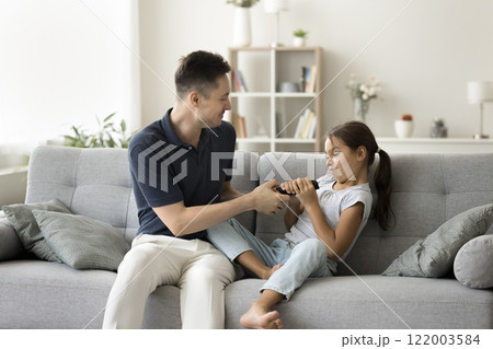 Dad and daughter fighting for remote controller from tv 122003584