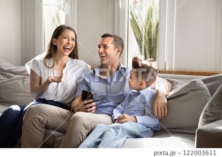 Cheerful mom, dad and little son boy resting on sofa Cheerful mom, dad and little son boy resting on sofa 122003611