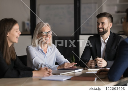 Laughing teammates, diverse professionals negotiating in modern boardroom 122003698