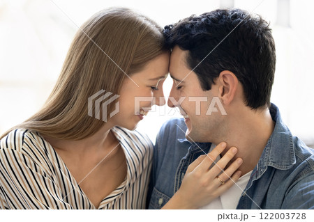 Happy Latin couple hugging with closed eyes and heads touch 122003728