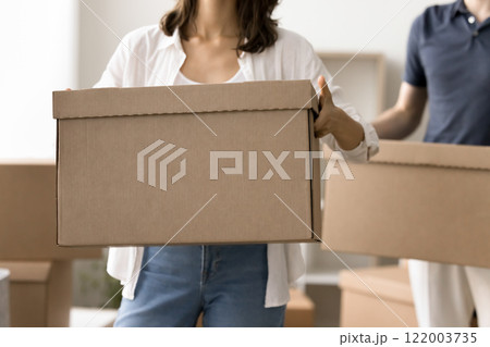 Close up cropped view couple holding moving boxes Close up cropped view couple holding moving boxes 122003735