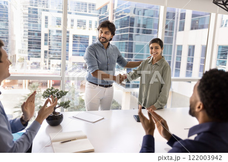 Positive male Indian boss shaking hands with happy employee 122003942