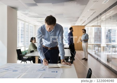 Focused busy young company owner man assessing business risk Focused busy young company owner man assessing business risk 122004040