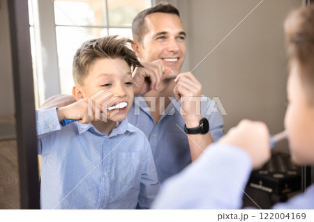 Cheerful dad and sweet son kid brushing teeth together 122004169