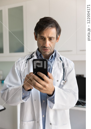 Serious doctor man using mobile phone for Internet communication 122004171