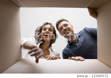 Happy couple getting long awaited parcel, cardboard box bottom view 122004172