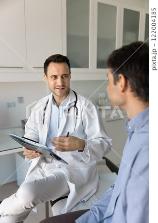 Positive general practitioner man talking to patient on appointment 122004185