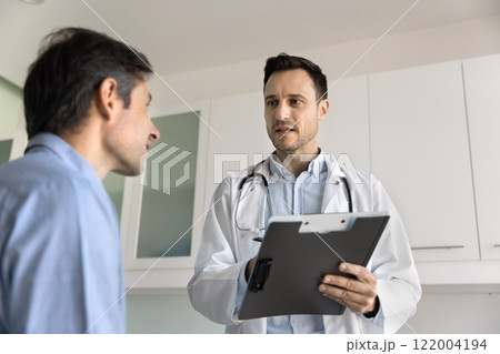 Serious general practitioner, cardiologist man talking to patient Serious general practitioner, cardiologist man talking to patient 122004194