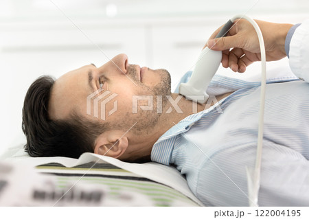 Side view of male patient visiting sonographer for examining thyroid 122004195