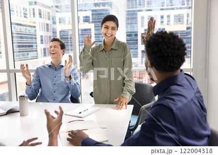 Cheerful excited multiethnic business friends raising hands for high five Cheerful excited multiethnic business friends raising hands for high five 122004318