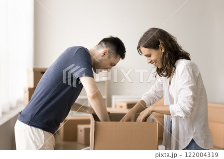 Young couple unpack their belongings stacked in boxes 122004319