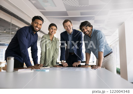 Multiethnic team of ambitious young colleagues standing at workplace 122004348