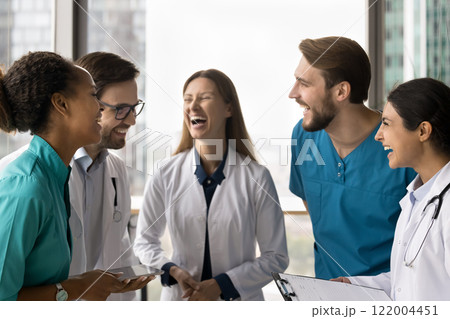 Happy clinic staff members laughing gathered together in clinic office 122004451
