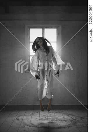 Creepy scene with pale, dark-haired woman in white gown levitating in air with hypnotic gaze, illuminated by light from a window. 122004564