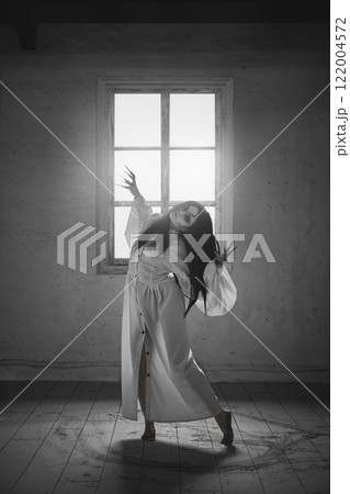 Woman with long dark hair, flowing white dress, black claws stands in dramatic pose, expressing supernatural allure, mysticism. Black and white photography Woman with long dark hair, flowing white dress, black claws stands in dramatic pose, expressing supernatural allure, mysticism. Black and white photography 122004572