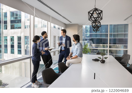 Diverse coworkers talking in office meeting room 122004689