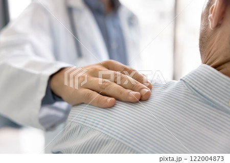 Supportive hand of doctor touching male back and shoulder 122004873