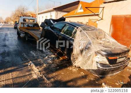evacuation of an emergency vehicle from the road. loading a wrecked car onto a tow truck evacuation of an emergency vehicle from the road. loading a wrecked car onto a tow truck 122005158