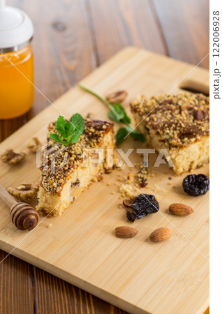 Sponge cake with prunes and nuts on wood 122006928