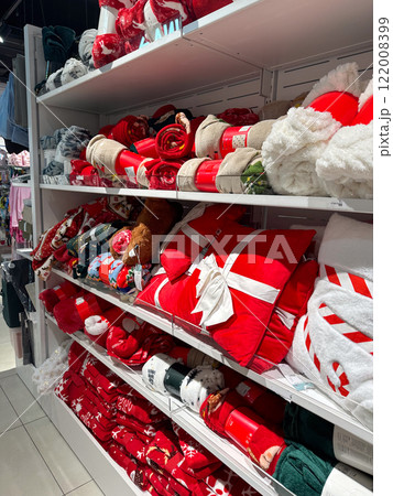 Shelves in shop filled with bright red and festive Christmas holiday blankets and decor items. Cheerful and seasonal atmosphere in the store 122008399