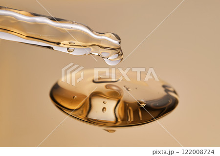 A pipette with a beautiful drop of gel-textured facial serum. A pipette with a beautiful drop of gel-textured facial serum. 122008724