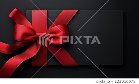 Elegant black gift card with a luxurious red ribbon and bow, copy space 122010078