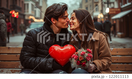 A man and woman sitting on a bench with a red heart 122011113