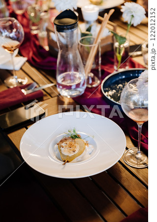 Gourmet poached pear dessert served on an elegant dining table with chic decor and fine wine 122012152