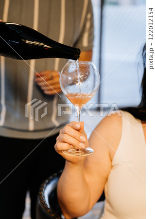 Elegant wine pouring at a formal dinner setting, highlighting refined taste and sophistication 122012154