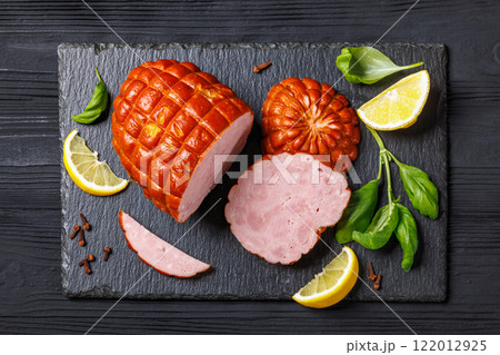 boneless smoked ham on black slate board, top view 122012925