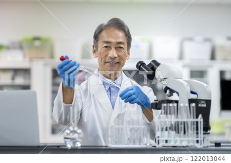 実験をするベテランの研究員　カメラ目線のポートレート 122013044