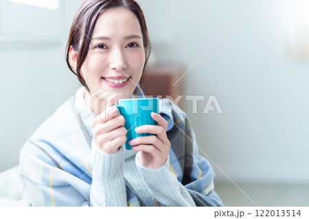 ホットドリンクを飲んで体を温める女性 122013514