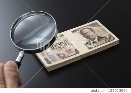 黒背景に虫眼鏡と100万円 122013923