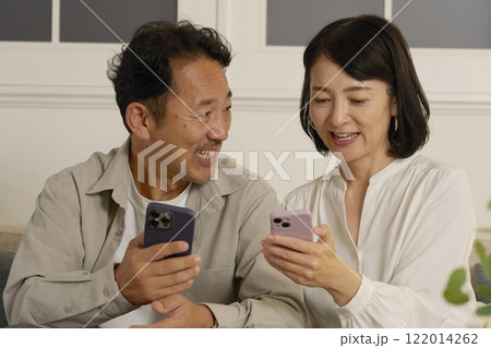 夜のリビングでスマホを使う熟年夫婦 夜のリビングでスマホを使う熟年夫婦 122014262