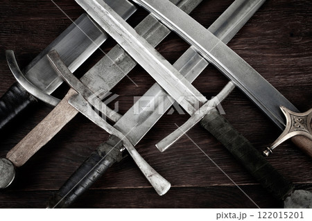 Swords and sabre on wooden background. 122015201