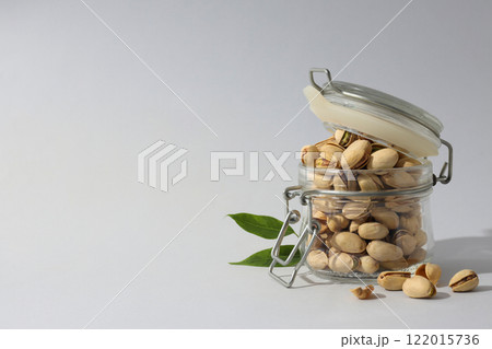 Pistachios in a glass jar, on a green background. Pistachios in a glass jar, on a green background. 122015736